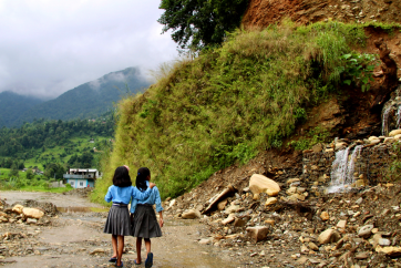 children walking by a road with erosion